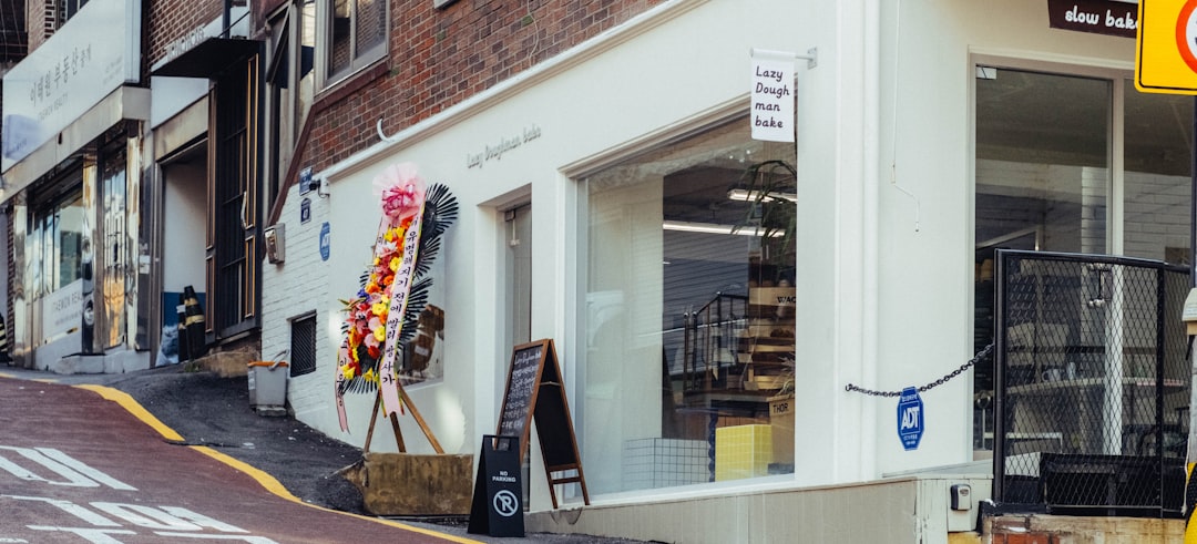 A white storefront with flowers and a chalkboard sign.