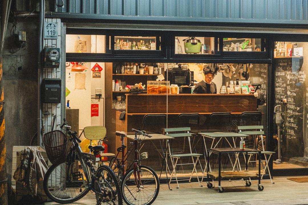 A cozy cafe storefront with tables outside at night