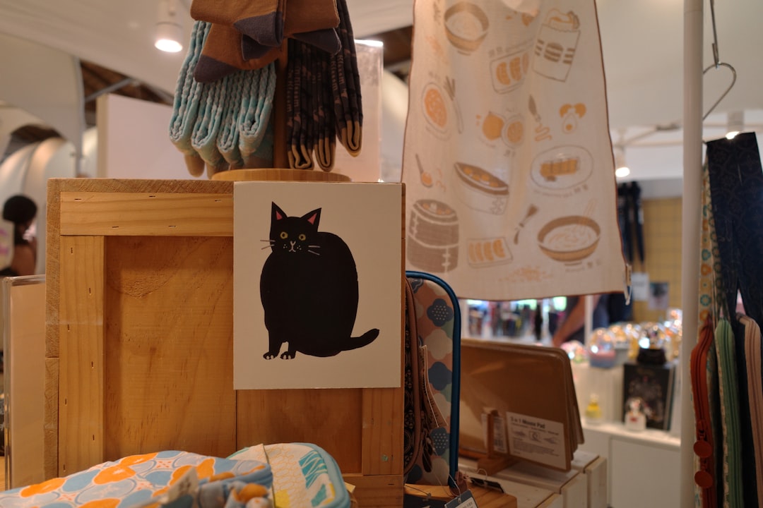 A black cat illustration on a wooden shelf.