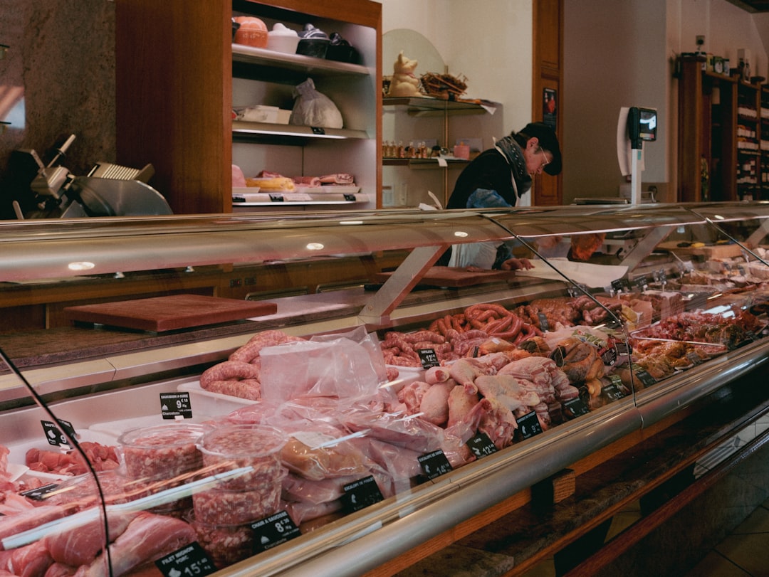 Butcher working behind a counter of fresh meat.