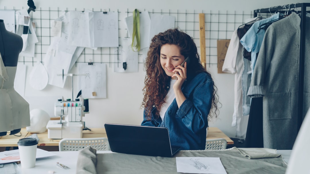 Fashion designer on the phone, working on a laptop