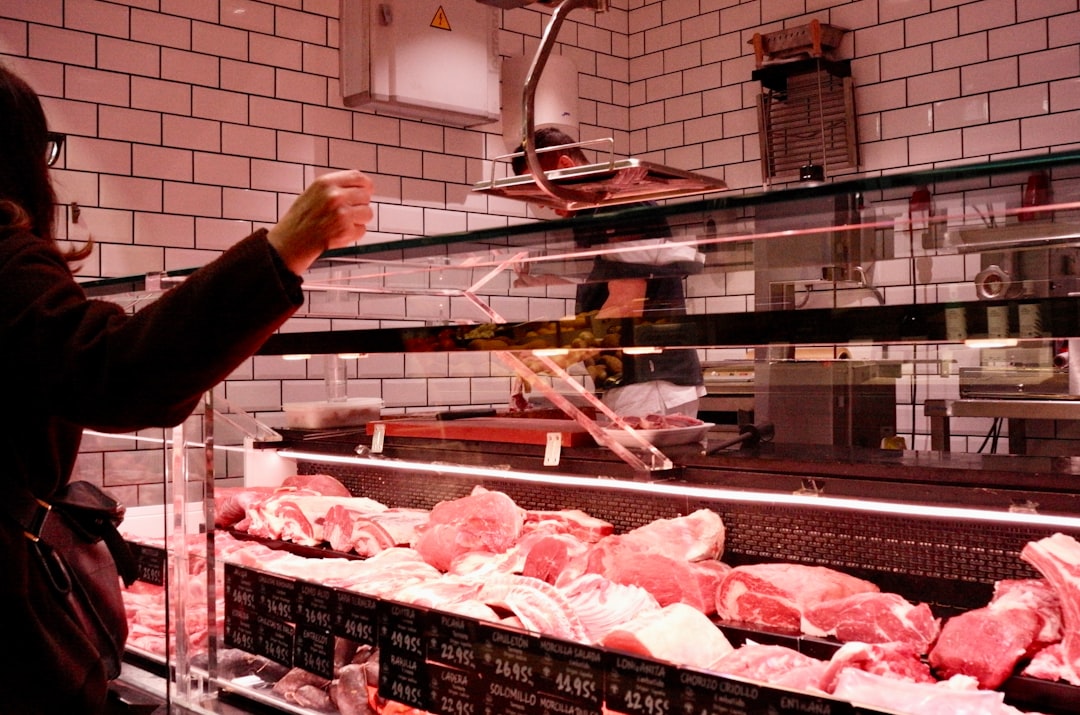 Customer selects raw meat from butcher display case